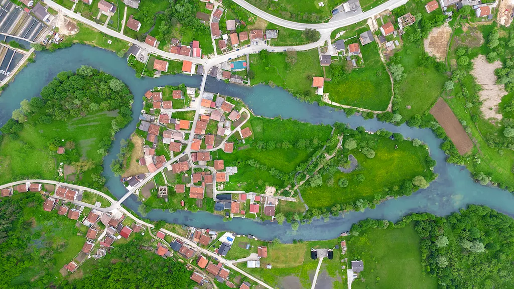 Rijeka vijuga kroz selo, snimljeno odozgo iz vazduha.